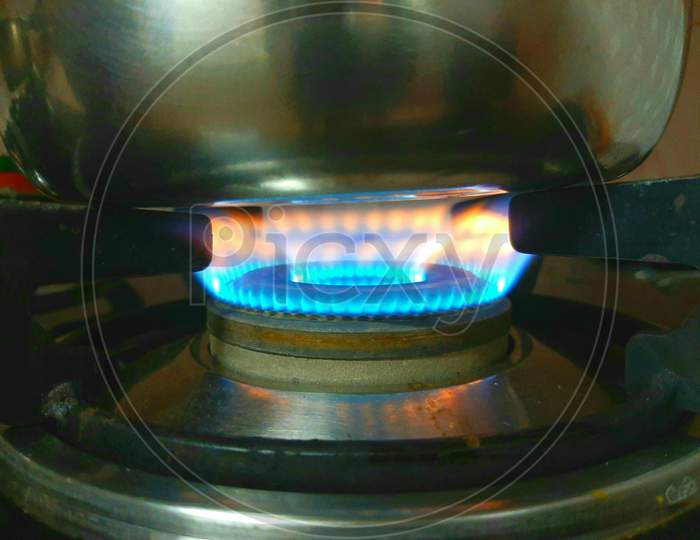 a flame burning on a gas stove in the kitchen  R