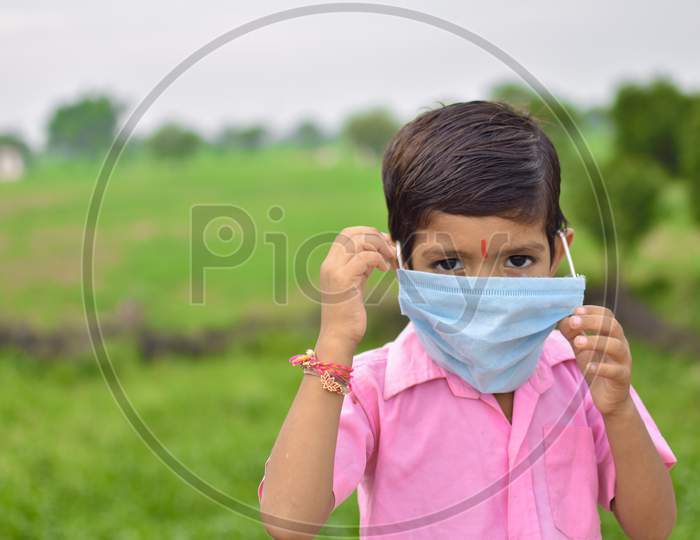 indian little kids using  blue mask on face in coronavirus