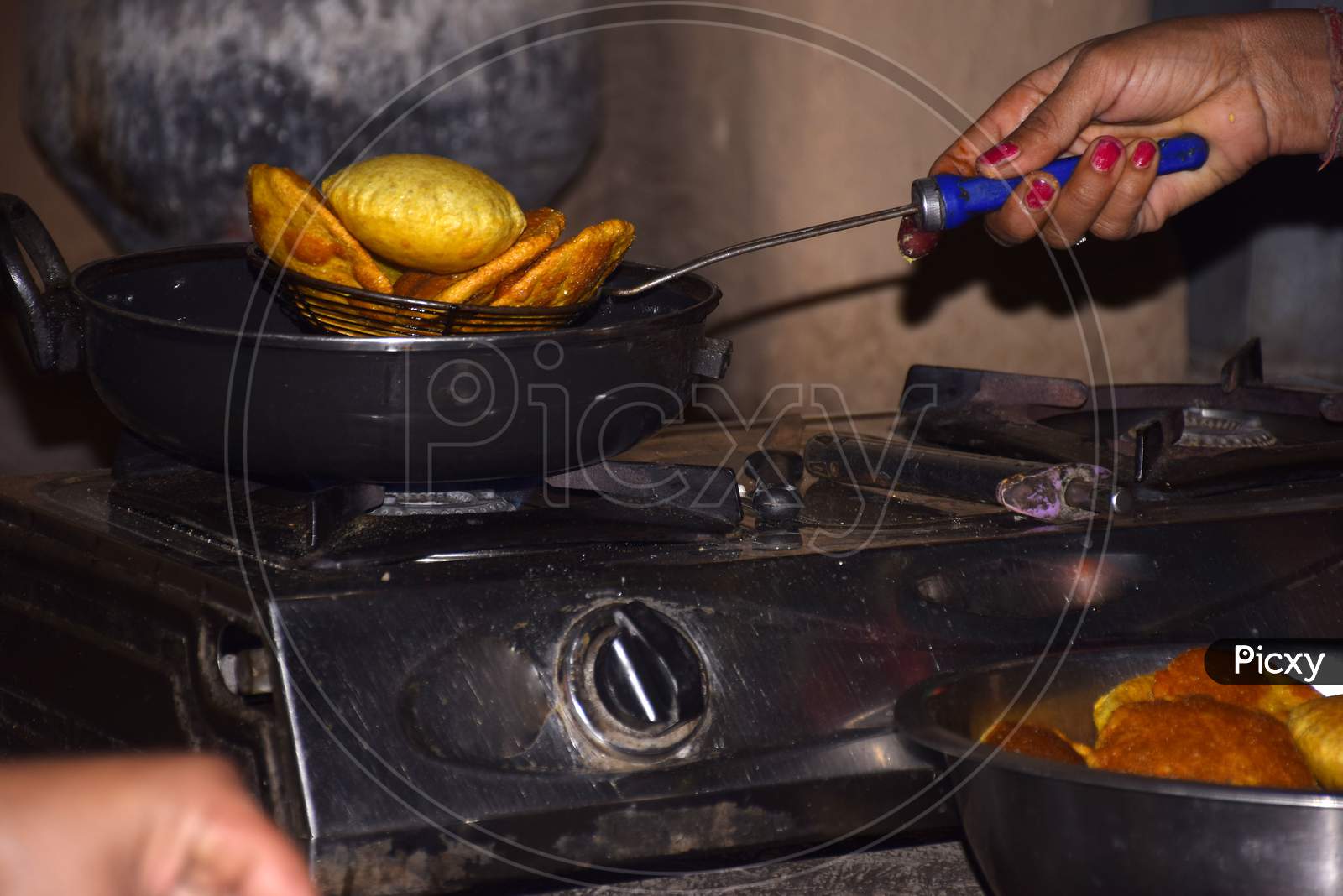Hands Of A Woman Frying Poodi On Lpg Gas Stove, Boiling Oil In Frying Pan With Dark Background