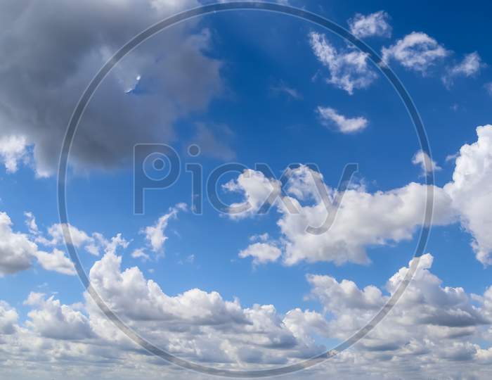Beautiful Fluffy White Cloud Formations In A Deep Blue Summer Sky
