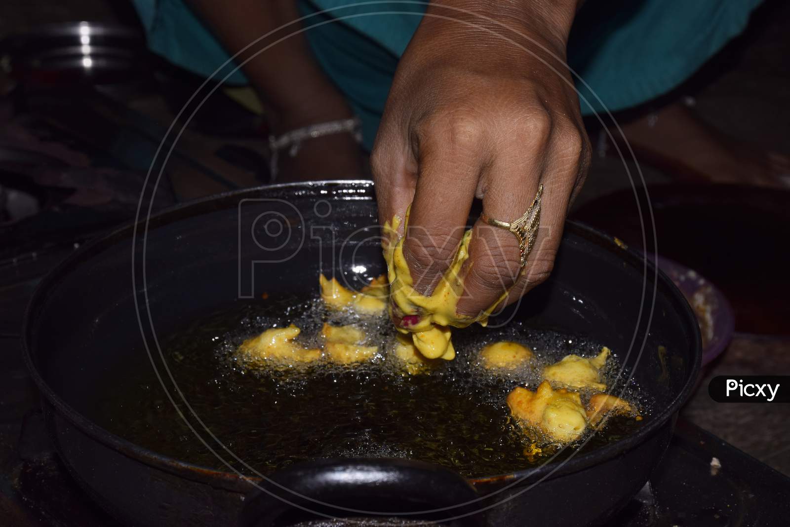 Hands Of A Woman Frying Gram Flour Snacks, Boiling Oil In Frying Pan With Dark Background