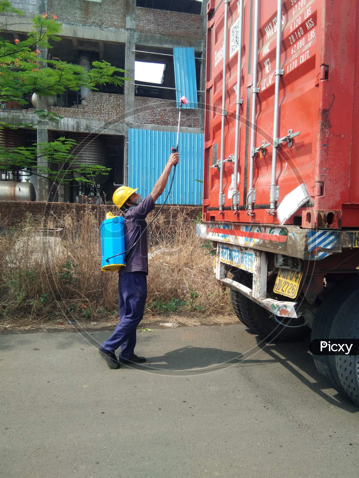 Indian factory worker sanitizing a truck