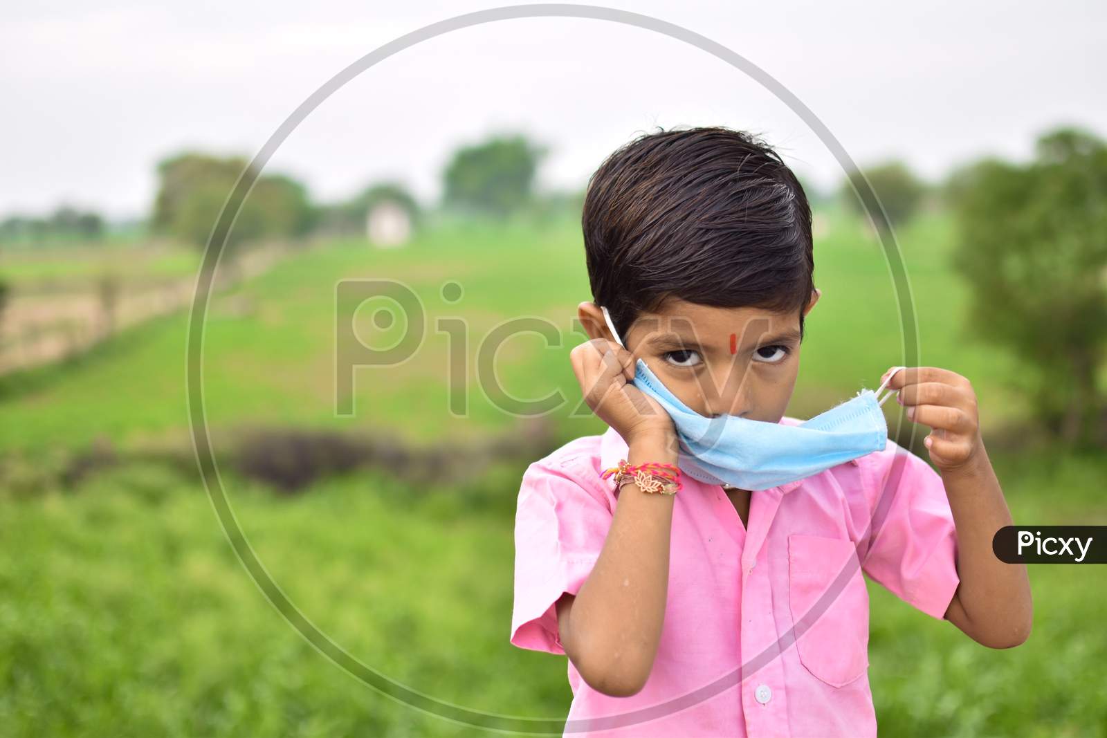 indian little kids using  blue mask on face in coronavirus