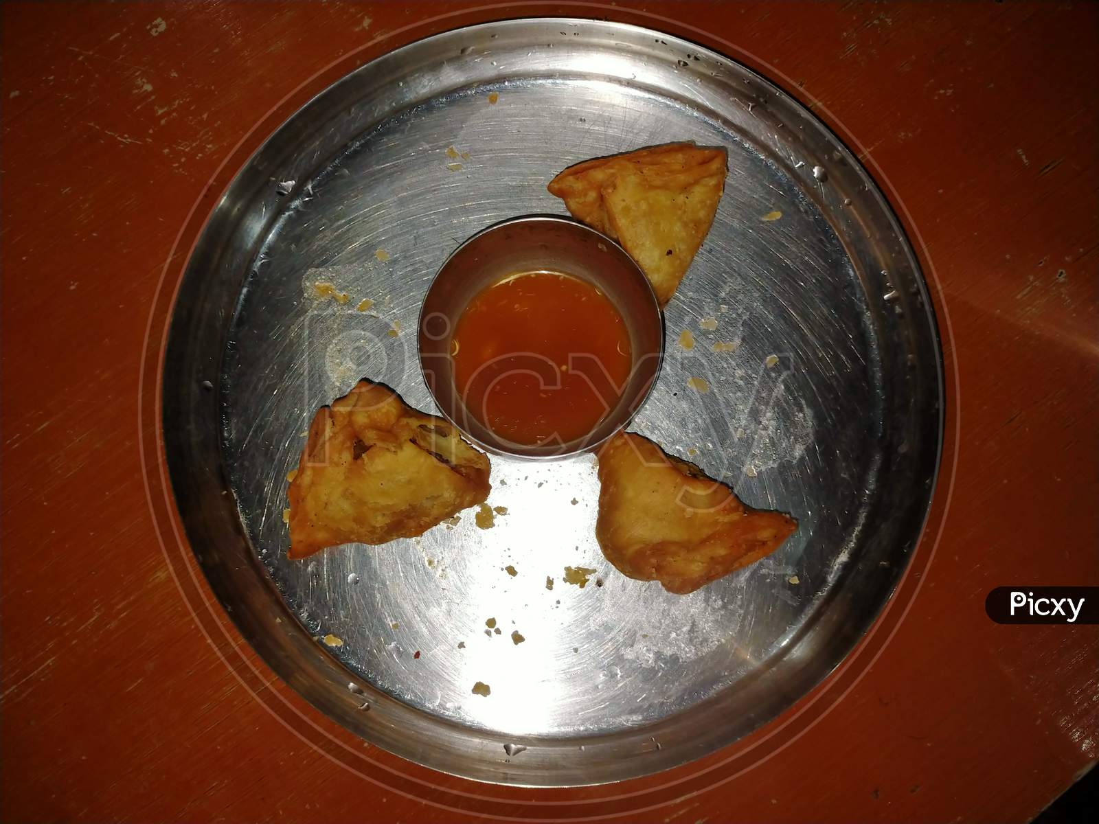 Samosa and chutney in a plate with black and grey background