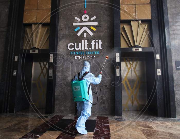 A man in personal protective equipment (PPE) sprays disinfectant to sanitize a mall before they reopen in Mumbai, India on July 30, 2020.