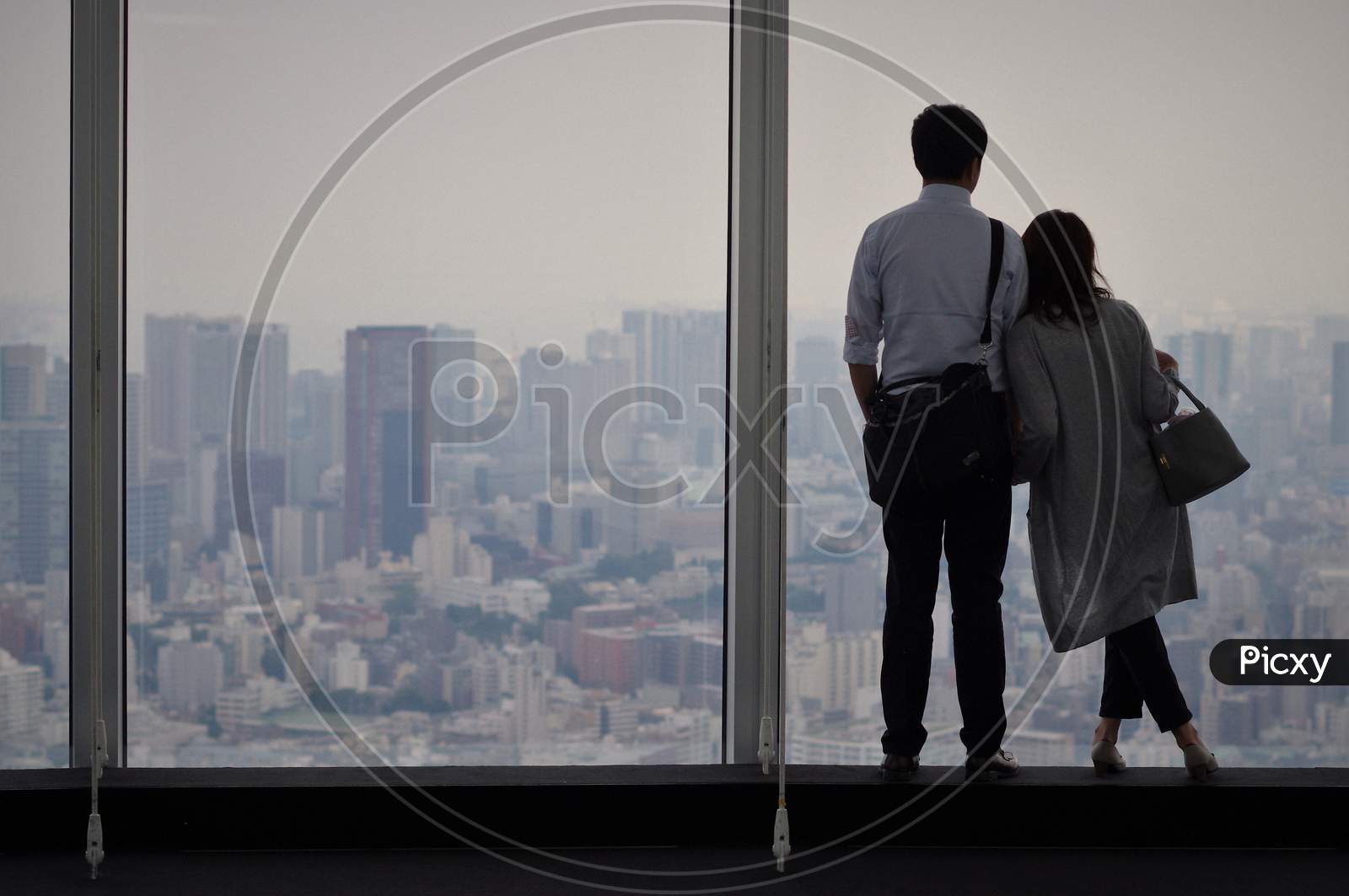 Shanghai - July 20 2020: A Pair Of Lovers Looking At A Beautiful View From A Tall Building With Full Glass Windows. Enjoy A Moment Of Time Together And Feel The Time Might Pause.