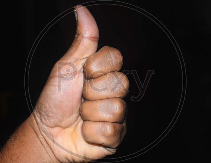 Closeup Of Hand Showing Thumbs Up Sign On Black Background With Clipping Path.