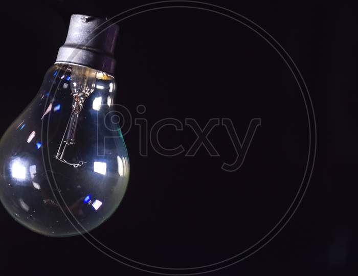 Light Bulb On Black Background, Close Up, Old Incandescent Lamp.