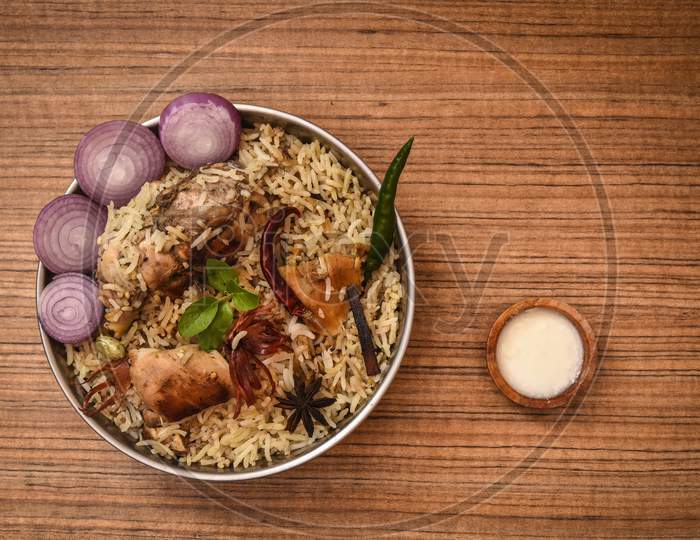 Delicious chicken biryani top view.Biryani rice dish Beautiful Indian rice dish.Delicious spicy chicken biryani in bowl over moody background, it’s a popular Indian and Pakistani food.