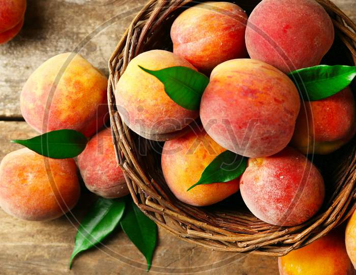 Red coloured and ripen peaches in basket
