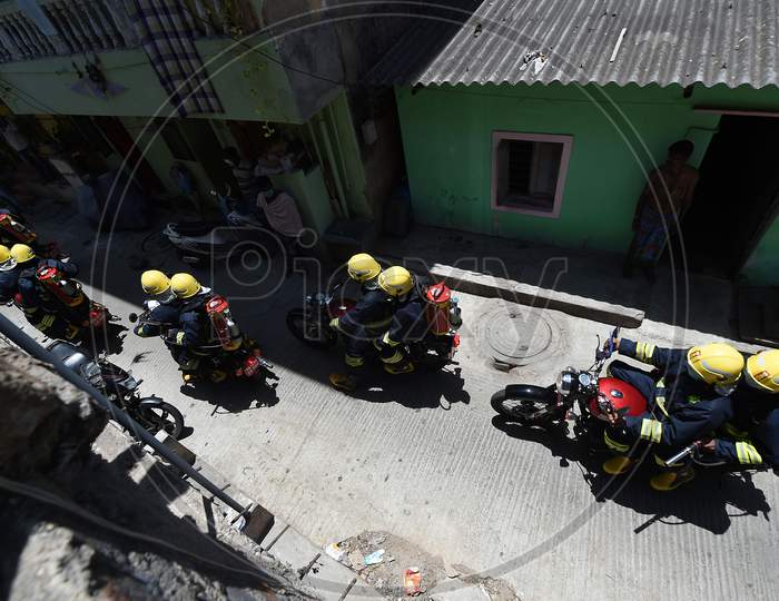 Firefighters on motorbikes equipped with disinfectants ride their way through a containment zone during the lockdown in Chennai on July 04, 2020.