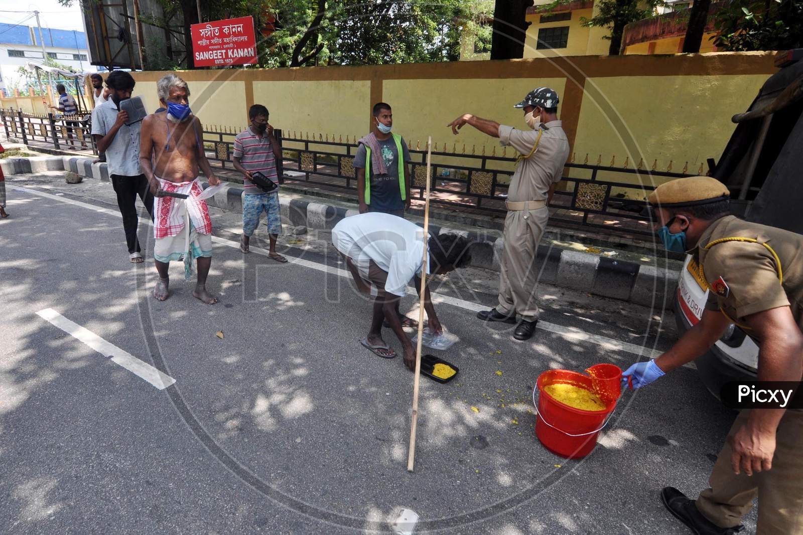 Police officers distribute food to people during the lockdown imposed by the Assam government to control the spread of coronavirus in Guwahati, Assam on July 04, 2020