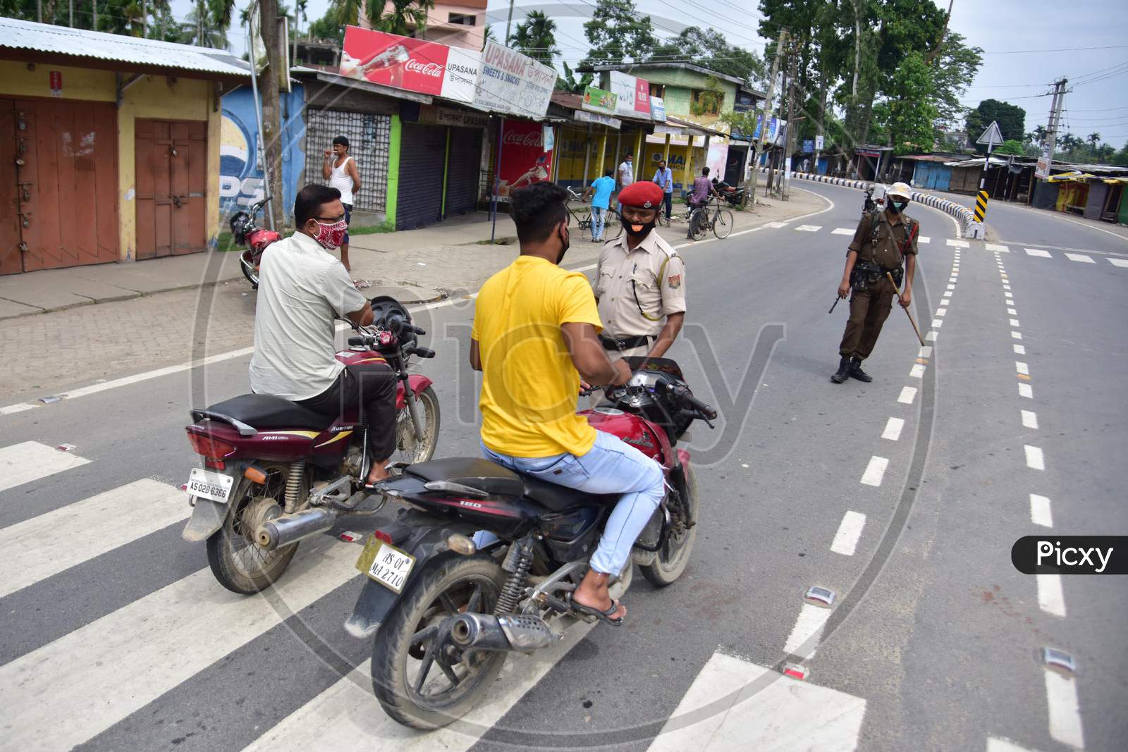 Police officers question bike riders during the lockdown imposed by the Assam government to curb the spread of coronavirus in Nagaon, Assam on July 04, 2020