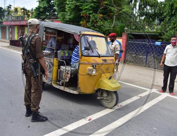 Security personnel question commuters who defied the curfew imposed during the lockdown by the Assam government to control the spread of the coronavirus in Nagaon, Assam on July 04, 2020