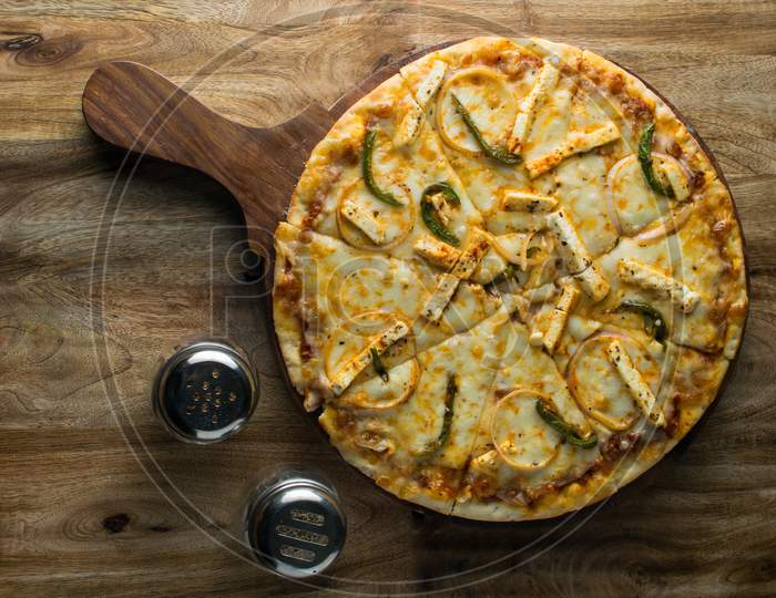 Pepperoni pizza on wooden board, Top view of delicious and crispy vegetarian pizza Margherita on light brown table background
