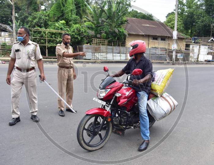 Police officers question a biker during the lockdown imposed by the Assam government to curb the spread of coronavirus in Nagaon, Assam on July 04, 2020