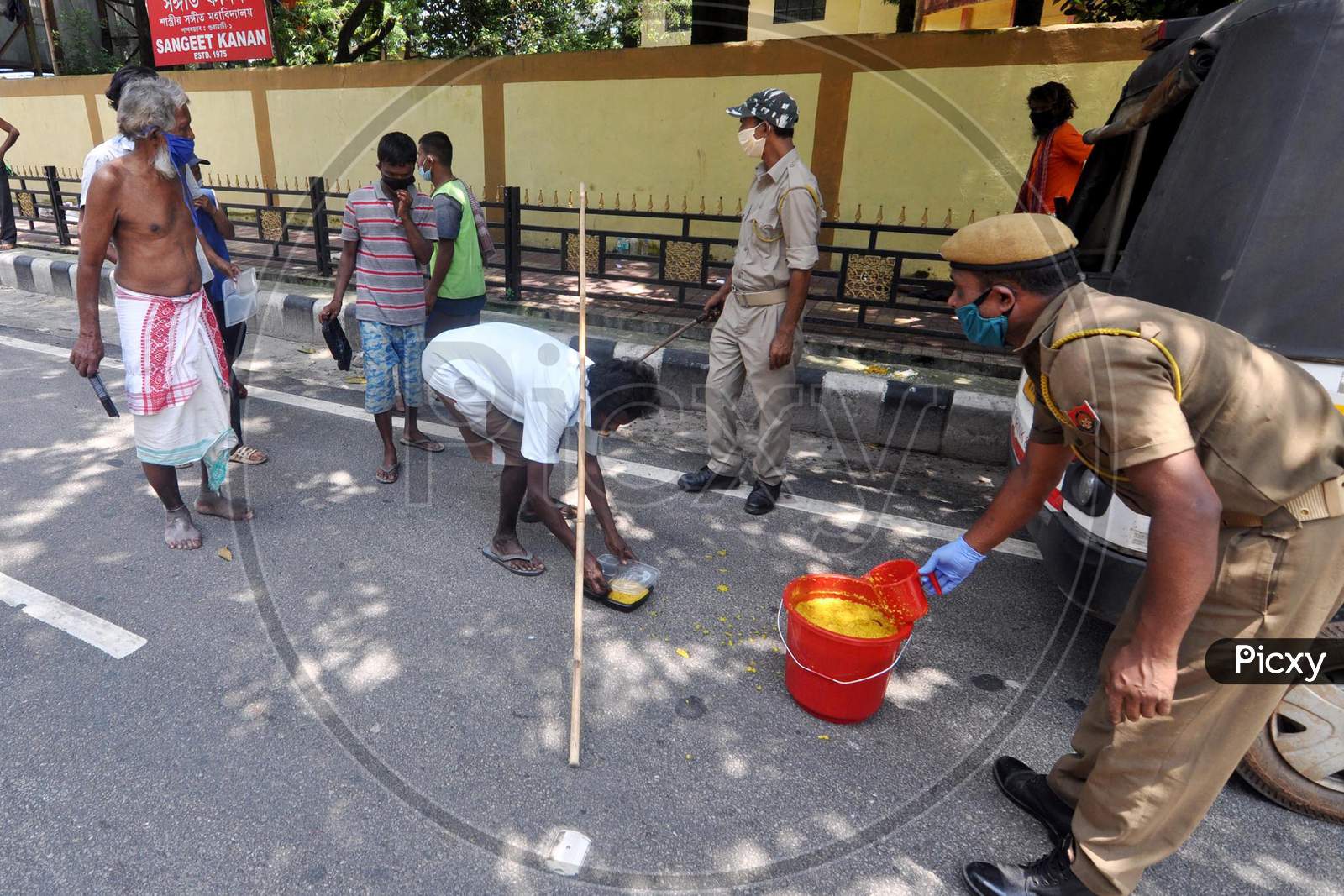 Police officers distribute food to people during the lockdown imposed by the Assam government to control the spread of coronavirus in Guwahati, Assam on July 04, 2020