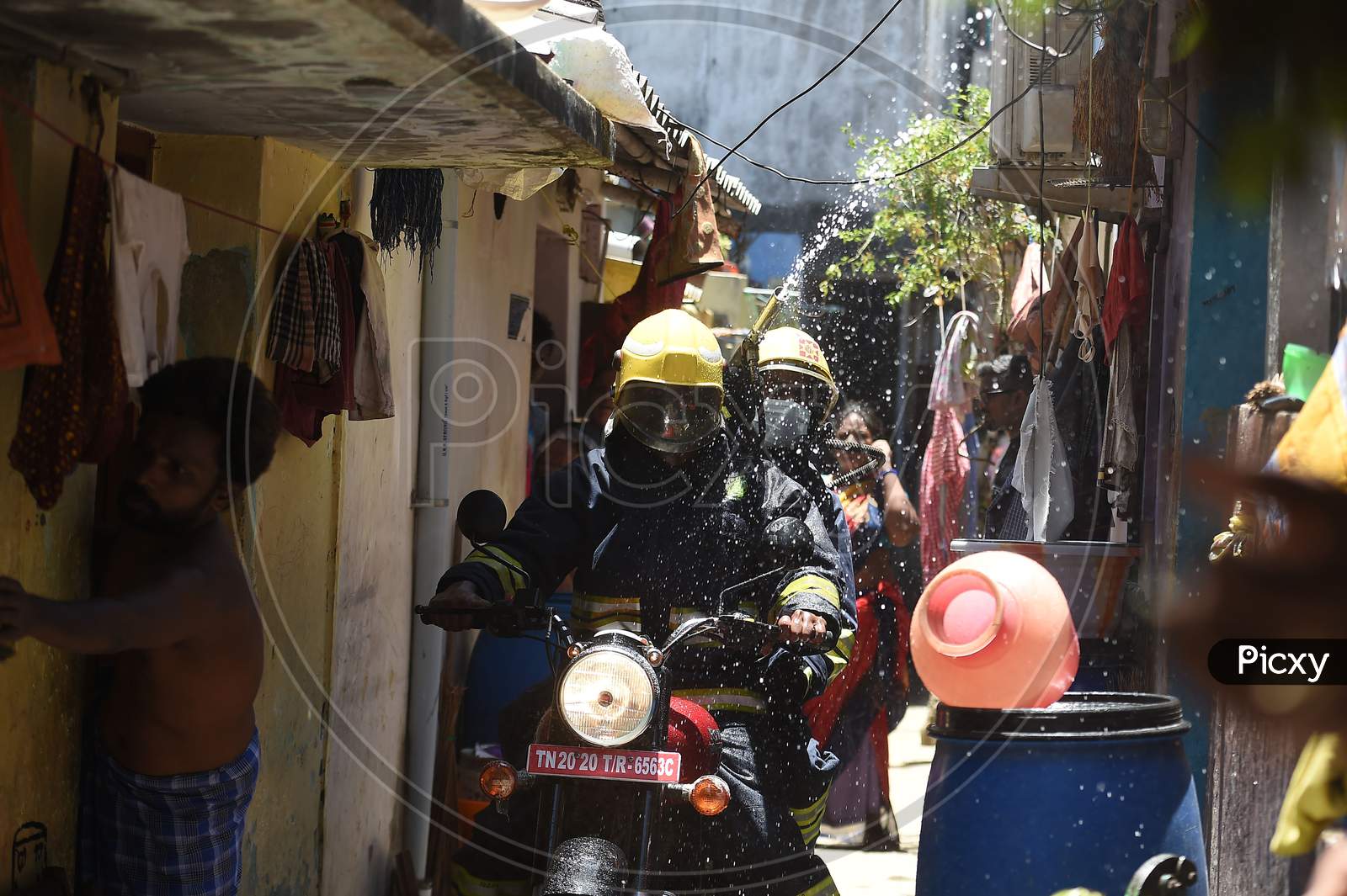 Firefighters on motorbikes spray disinfectants in a containment zone during the lockdown in Chennai on July 04 2020
