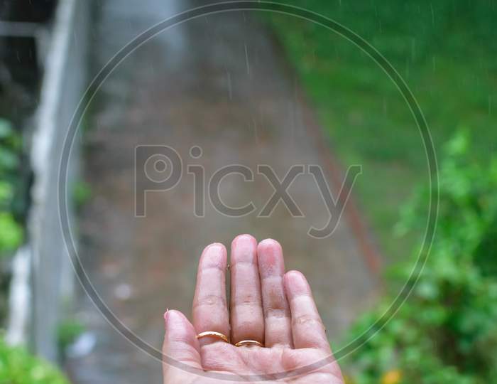Isolated Wet Human Hand With Rain Drops Falling On It. Portrait View