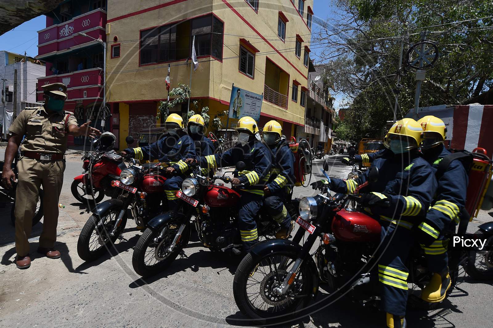 Firefighters on motorbikes equipped with disinfectants getting instructions from a police officer in a containment zone during the lockdown in Chennai