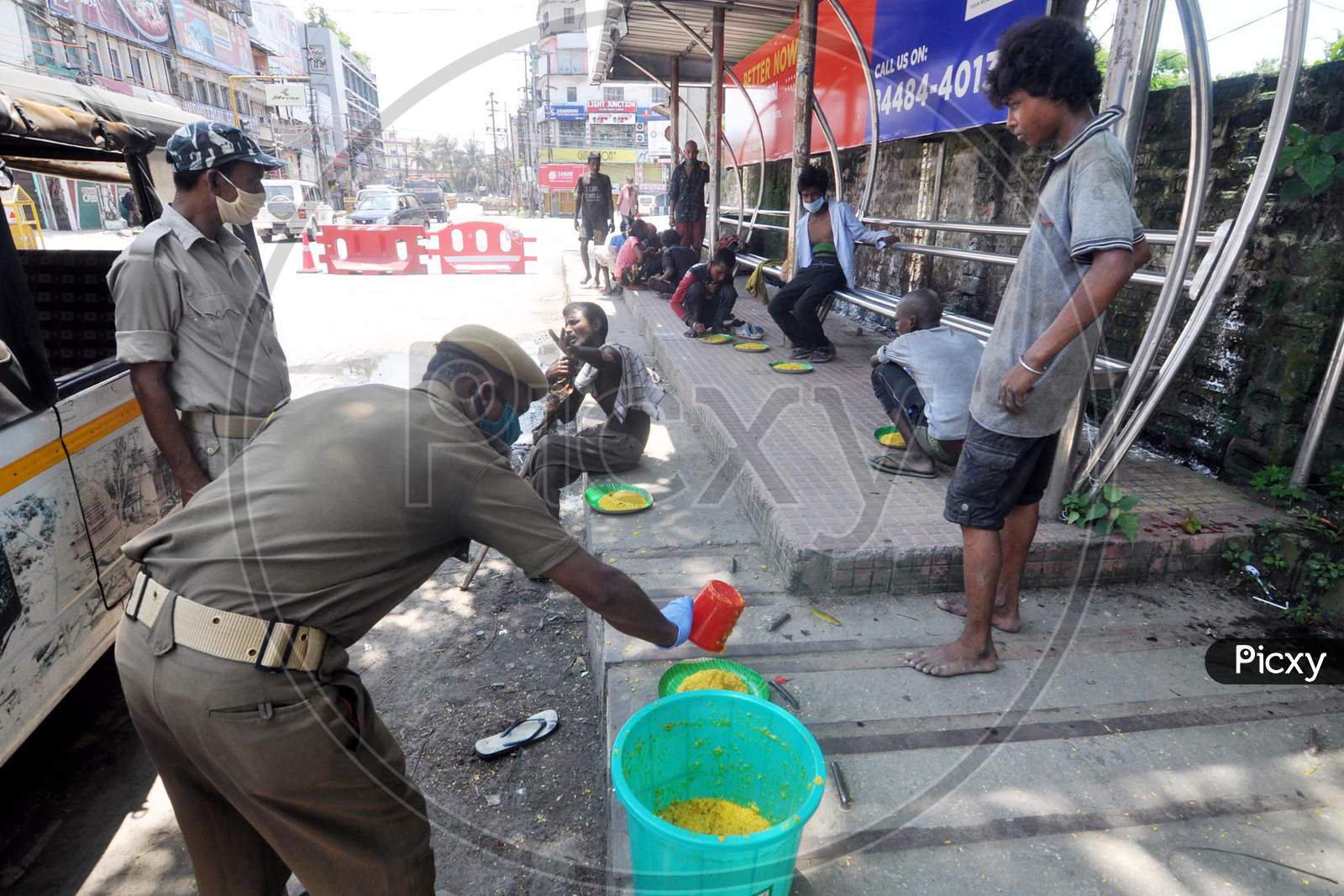 Police officers distribute food to homeless people during the lockdown imposed by the Assam government to control the spread of coronavirus in Guwahati, Assam on July 04, 2020
