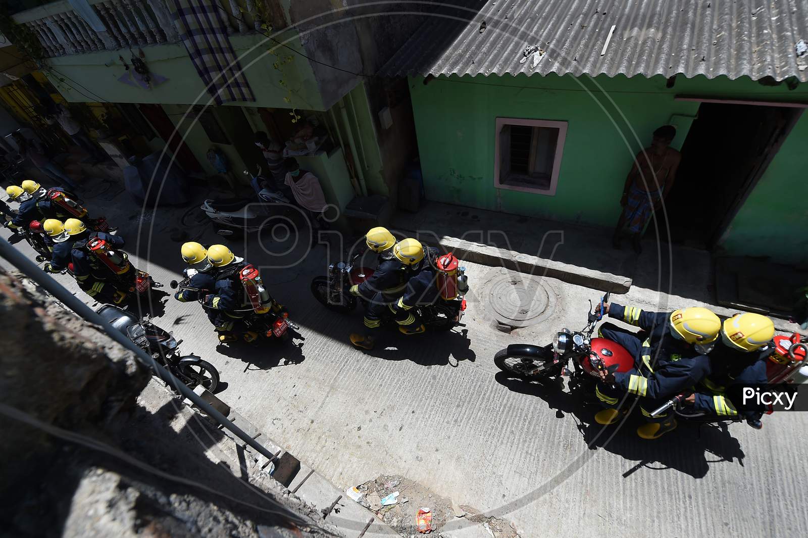 Firefighters on motorbikes equipped with disinfectants ride their way through a containment zone during the lockdown in Chennai on July 04, 2020.