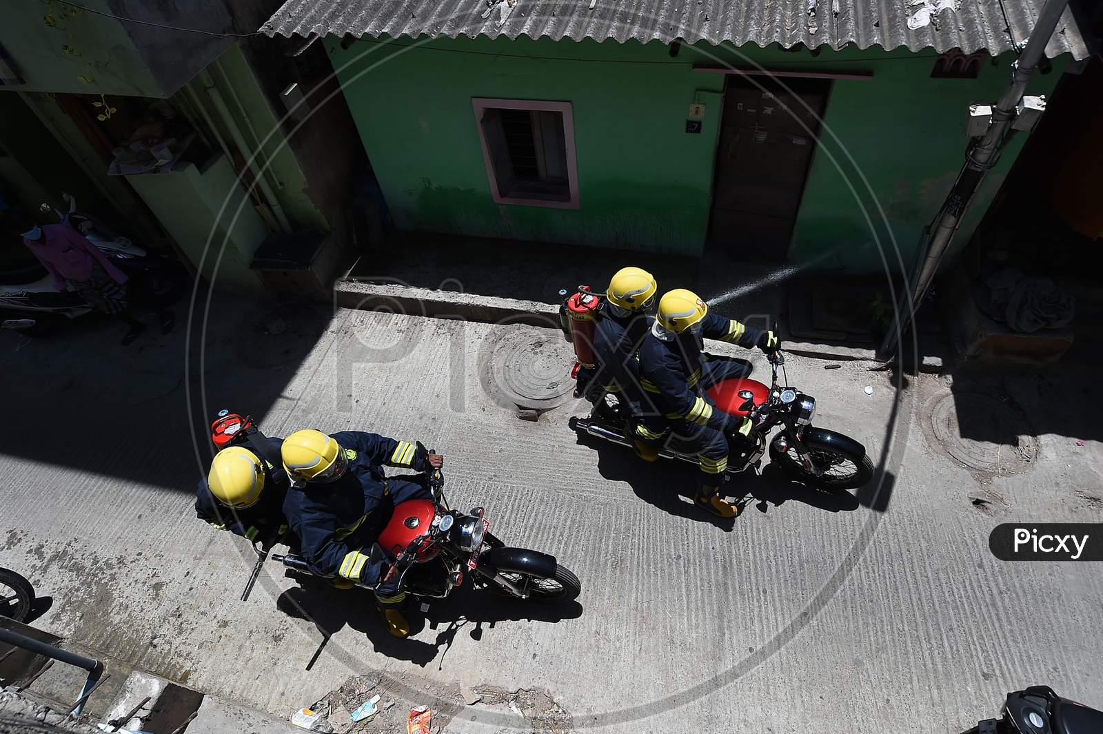 Firefighters on motorbikes spray disinfectants in a containment zone during the lockdown in Chennai on July 04, 2020