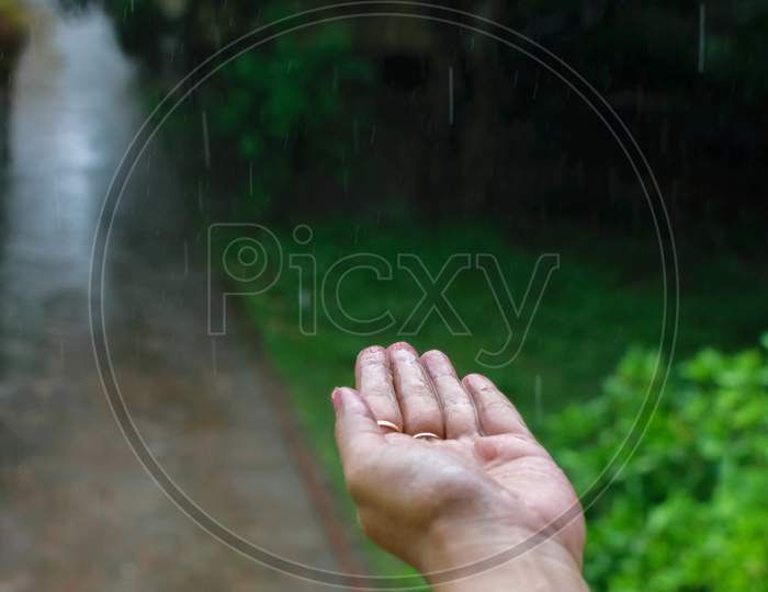 Isolated Wet Human Hand With Rain Drops Falling On It