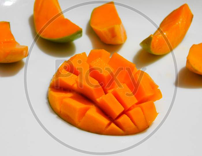 Carved mangoes isolated on a white background,Half cut ripen mango with square design surrounded by mango slice on white background.