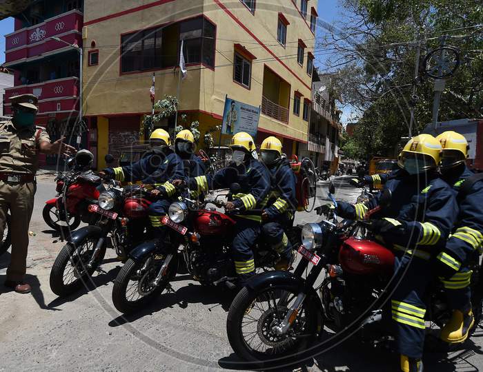 Firefighters on motorbikes equipped with disinfectants getting instructions from a police officer in a containment zone during the lockdown in Chennai