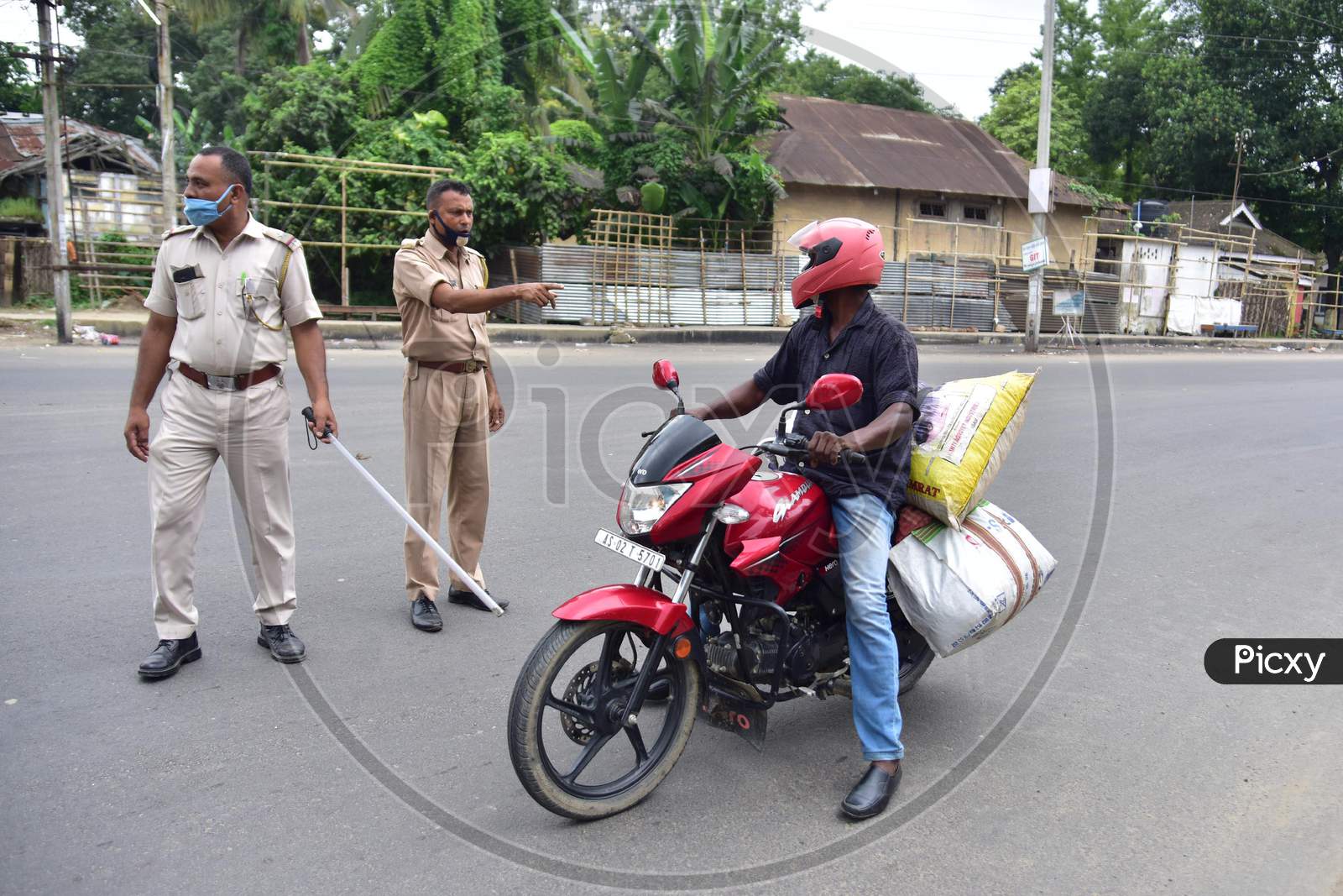 Police officers question a biker during the lockdown imposed by the Assam government to curb the spread of coronavirus in Nagaon, Assam on July 04, 2020