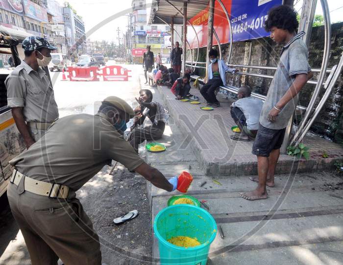 Police officers distribute food to homeless people during the lockdown imposed by the Assam government to control the spread of coronavirus in Guwahati, Assam on July 04, 2020