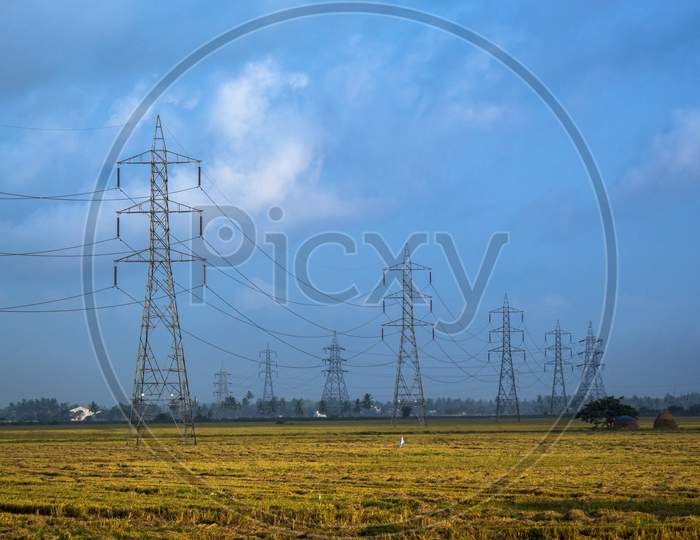 Electric transmission towers in rural field.