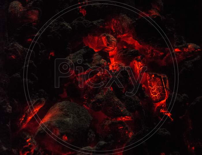 Burning And Glowing Charcoal Close-Up. Red Coals With Fire On A Black Background.