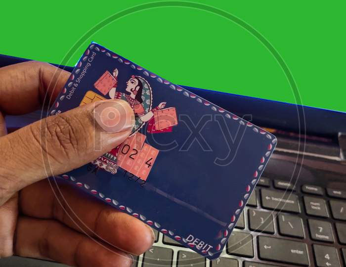 Person holding credit card over laptop green screen