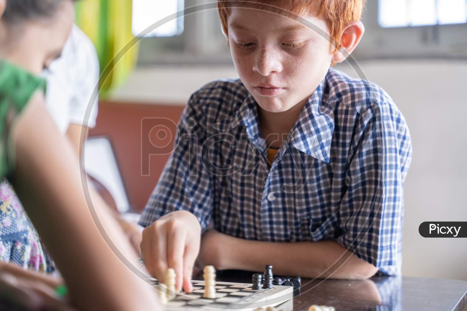 Serious Chess Player Kid Thinking And Moving Coin At Home - Concept Of Kid Concentration Of Game During Early Development, Home Educational Games For Children