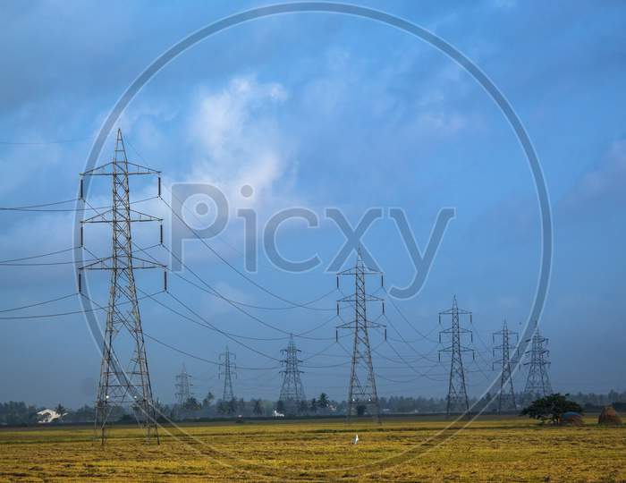 Electric transmission towers in rural field.