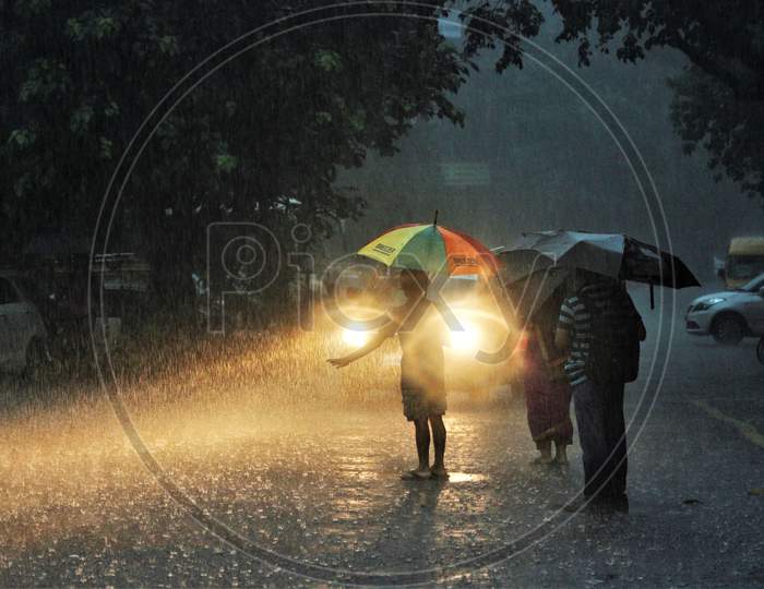 People wait for a taxi during heavy rains, in Mumbai on July 4, 2020.
