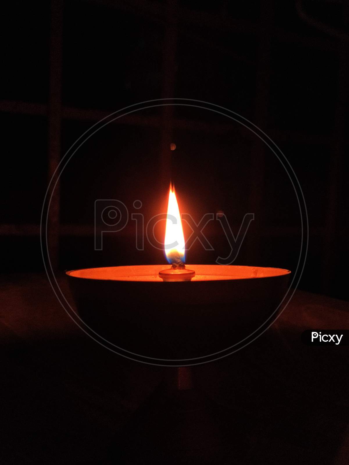 A Gold Color Diya with orange color light In A Balcony.