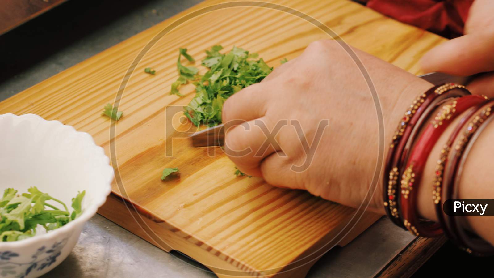 Woman Cutting Coriander leaves on chopping board