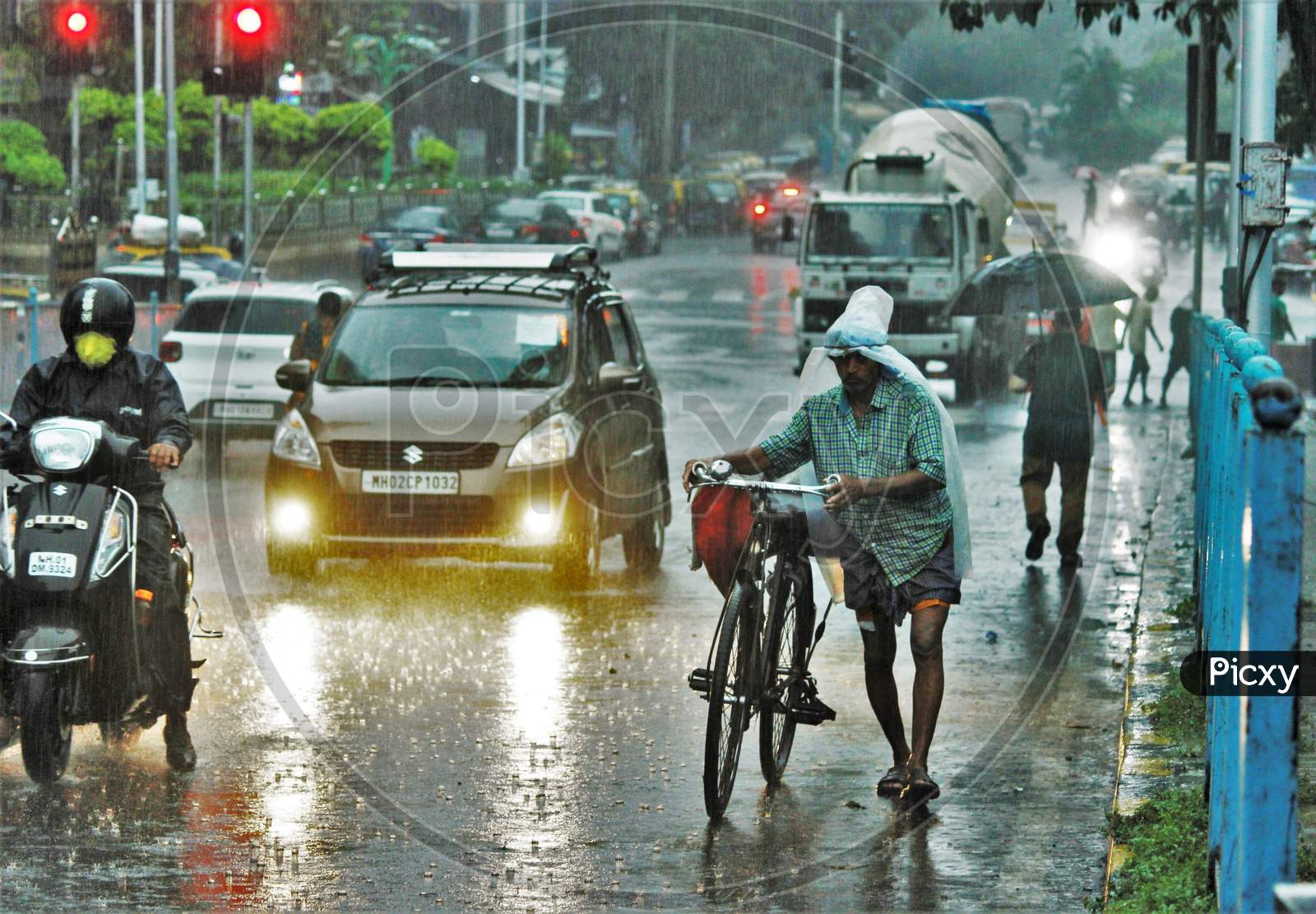 A man walks with his cycle during heavy rains, in Mumbai on July 4, 2020.