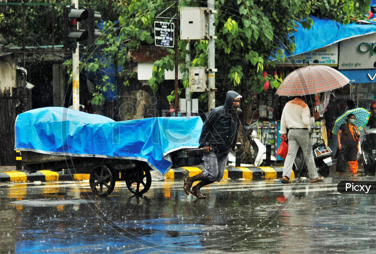 A man pulls a handcart during heavy rains, in Mumbai on July 4, 2020.
