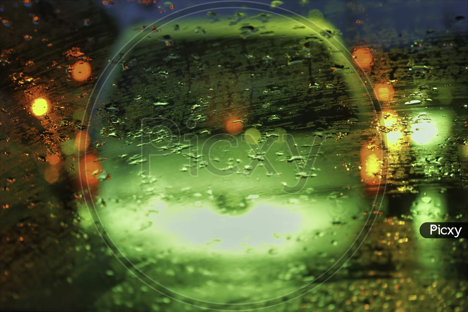 An Abstract Art Image Of Raindrops On A Glass Against Street Light