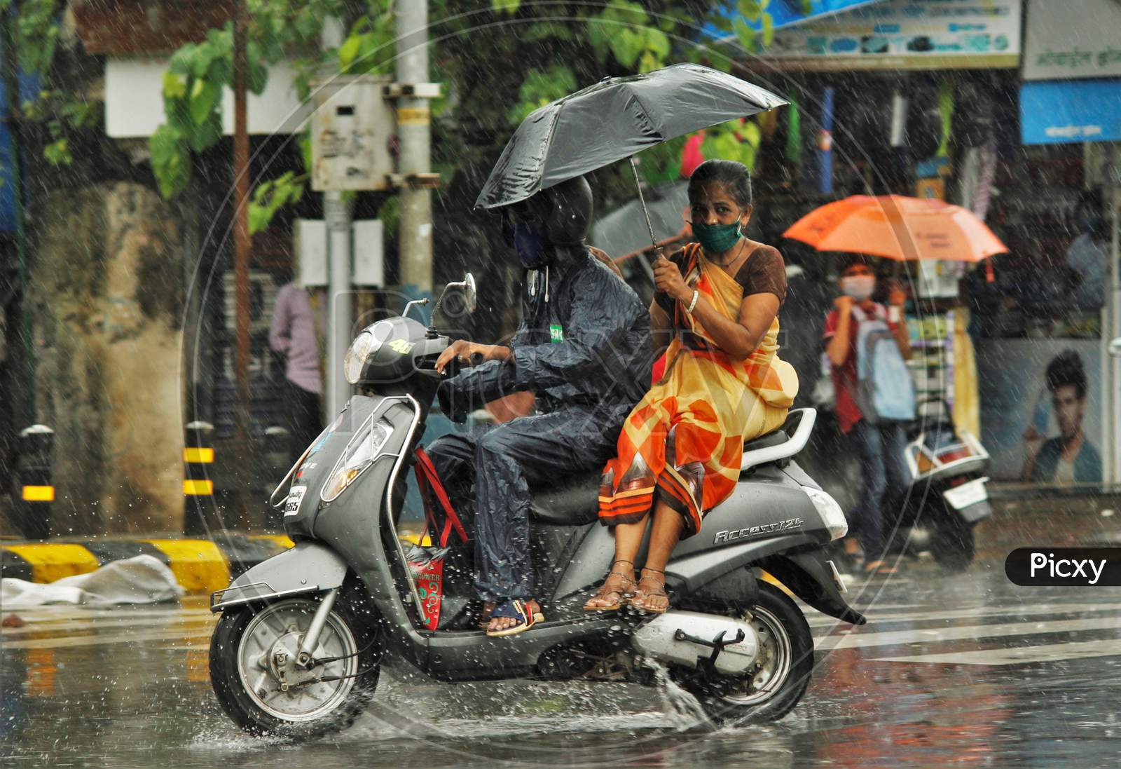 A man rides a bike during heavy rains, in Mumbai on July 4, 2020.