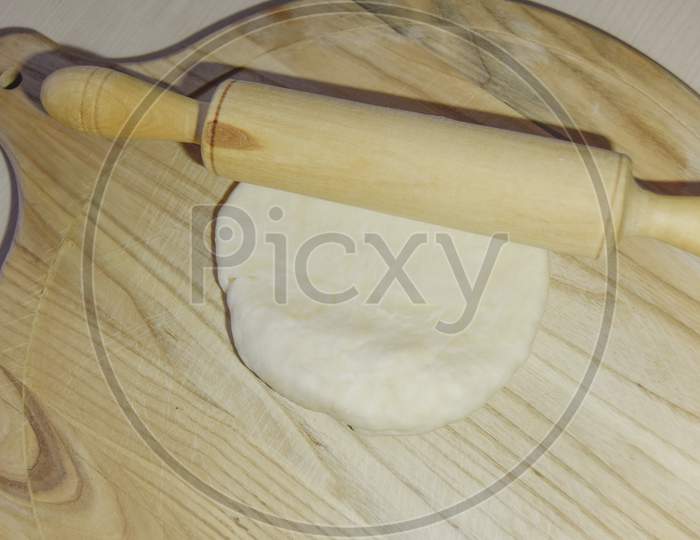 Selective Focus At The Dough And Roller On The Chopping Board