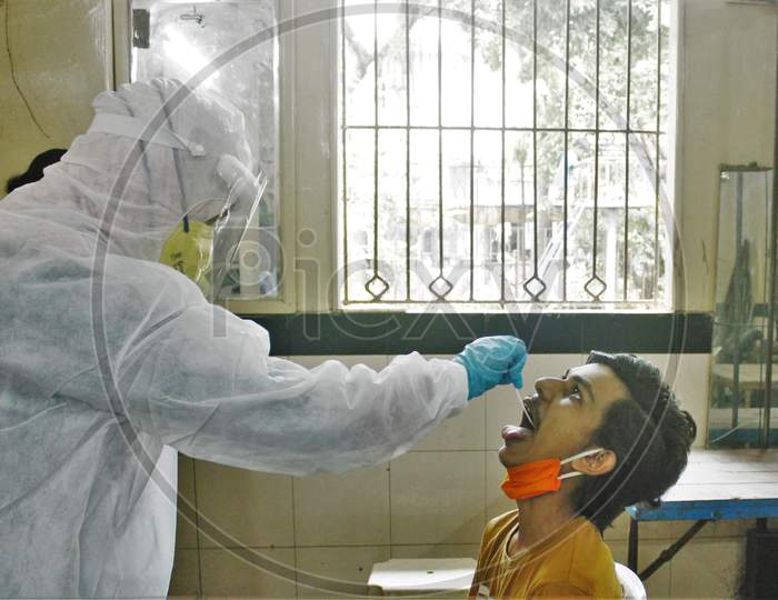 A healthcare worker wearing personal protective equipment (PPE) collects a swab sample from a resident during a check-up campaign for the coronavirus disease (COVID-19), in Mumbai, India on July 1, 2020.