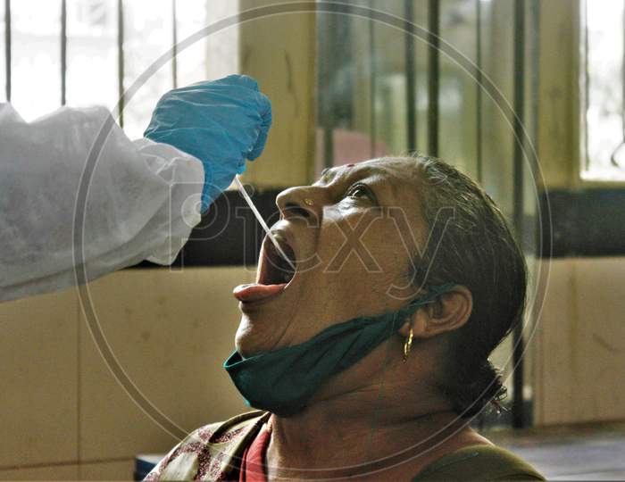 A healthcare worker collects a swab sample from a resident during a check-up campaign for the coronavirus disease (COVID-19), in Mumbai, India on July 1, 2020.