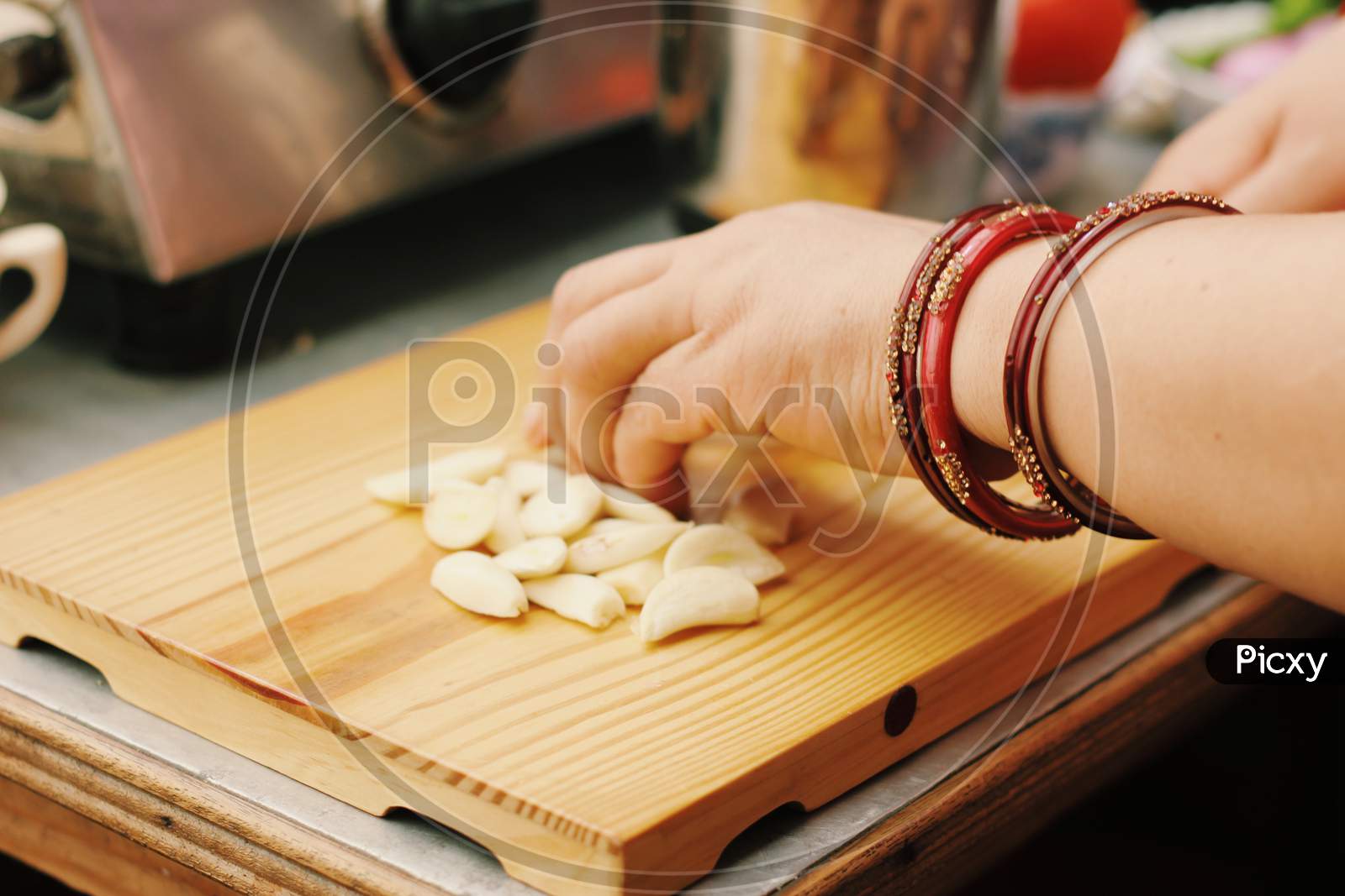 Woman Cutting Garlic on chopping board