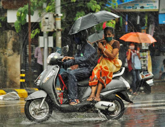 A man rides a bike during heavy rains, in Mumbai on July 4, 2020.
