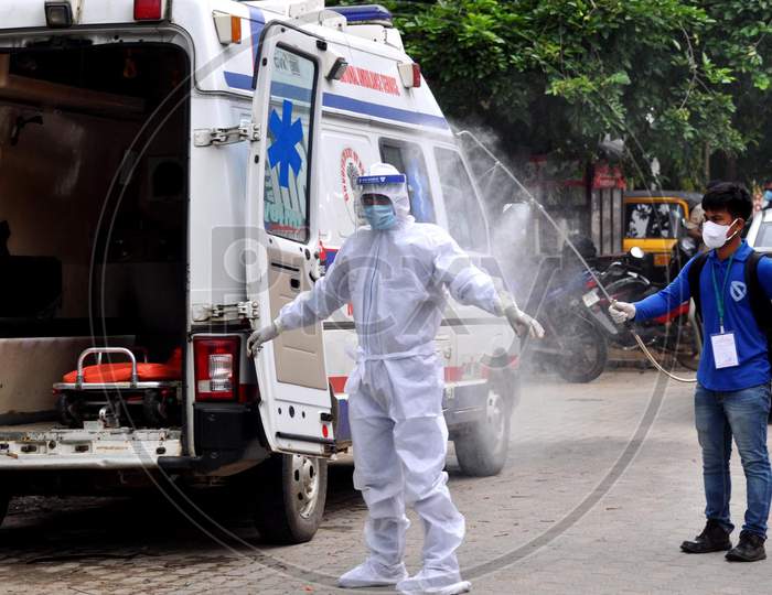 A health worker sprays disinfectant on a health worker outside a Covid-19 test collection center in Guwahati, Assam on July 06, 2020.